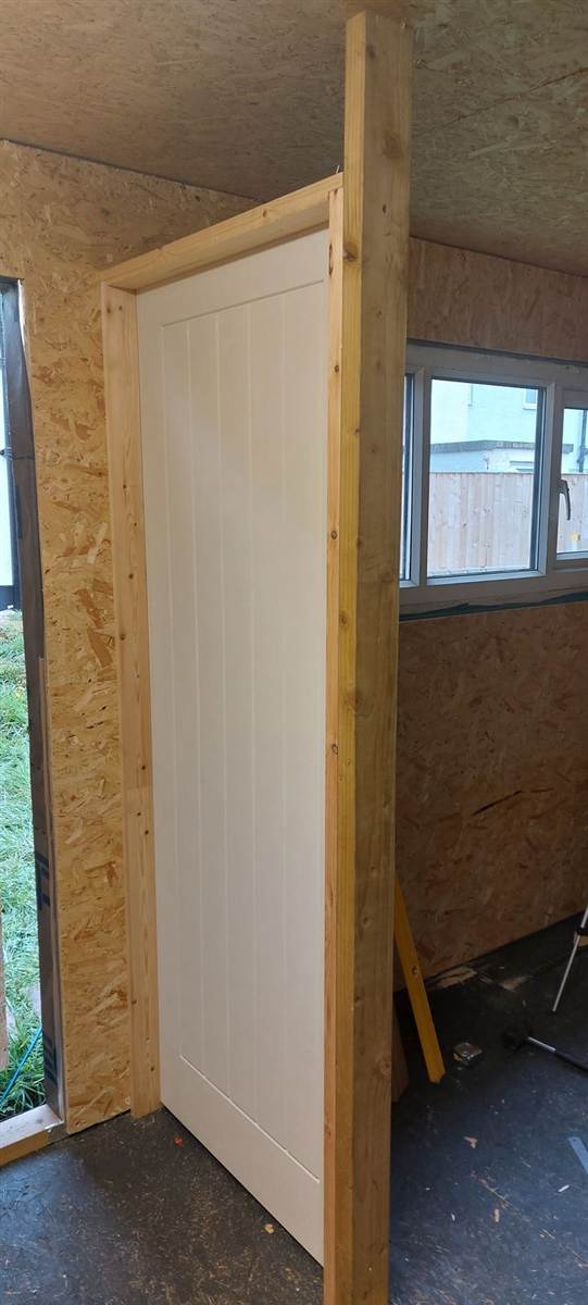 Foil-faced insulation taped across the full ceiling inside the building, OSB walls visible below